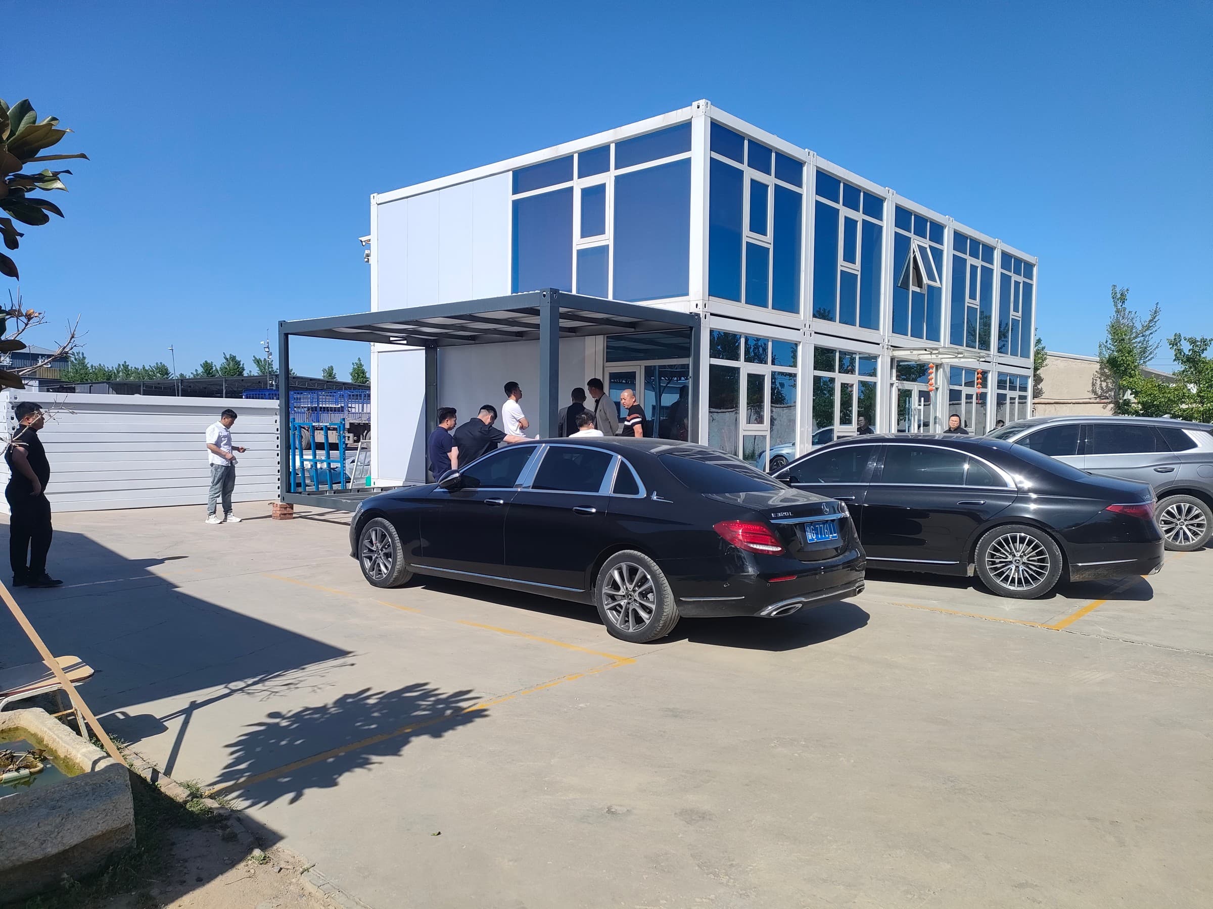 Manufacturing facility exterior with stacked structural panels and gantry crane