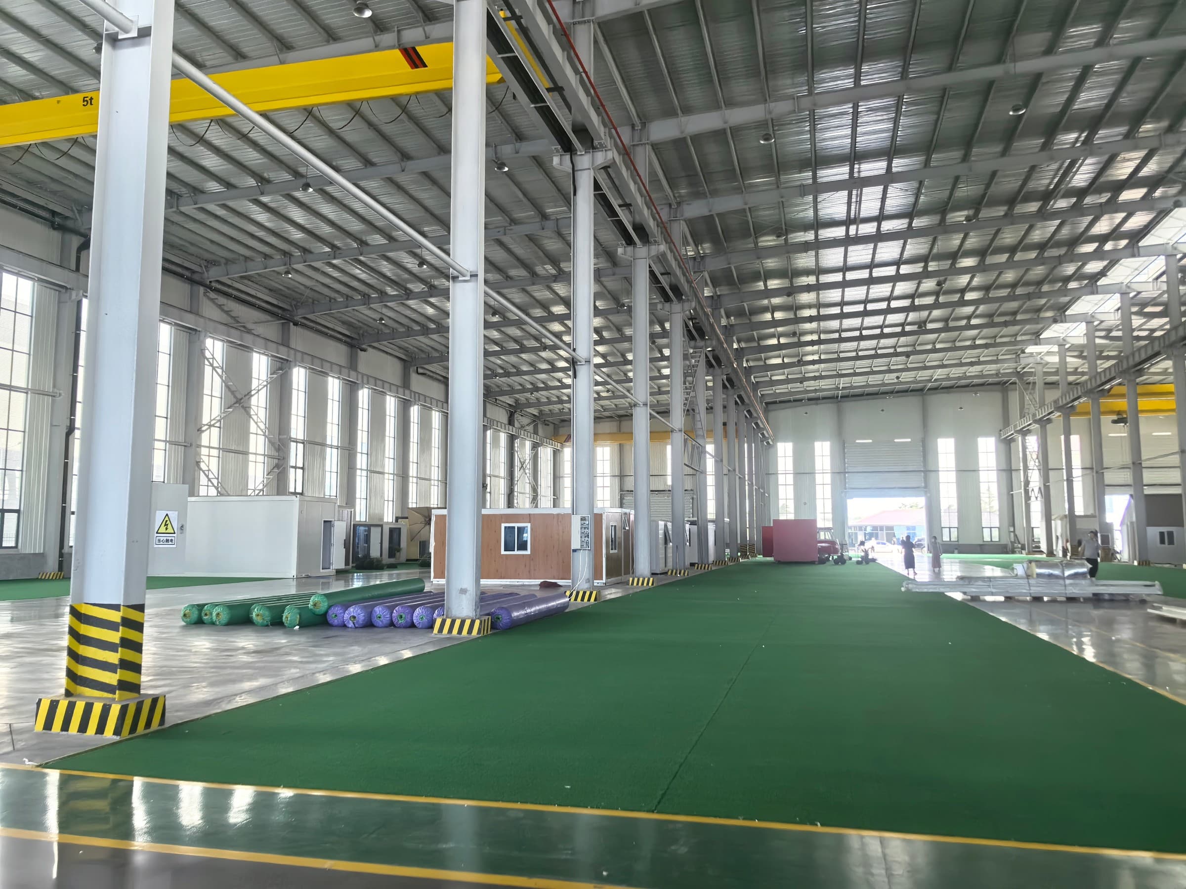 Wide interior view of the production hall with structural panels and container units in progress