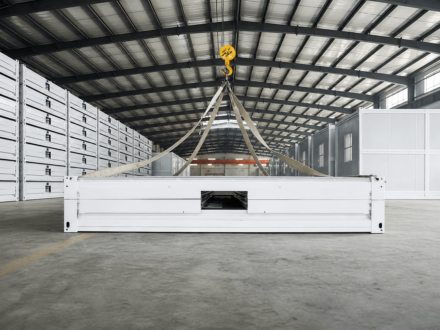 Container structure handled by an overhead crane inside the production hall