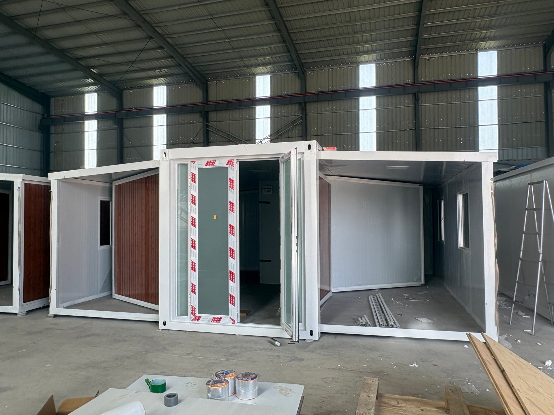 Structural module suspended by overhead crane during handling