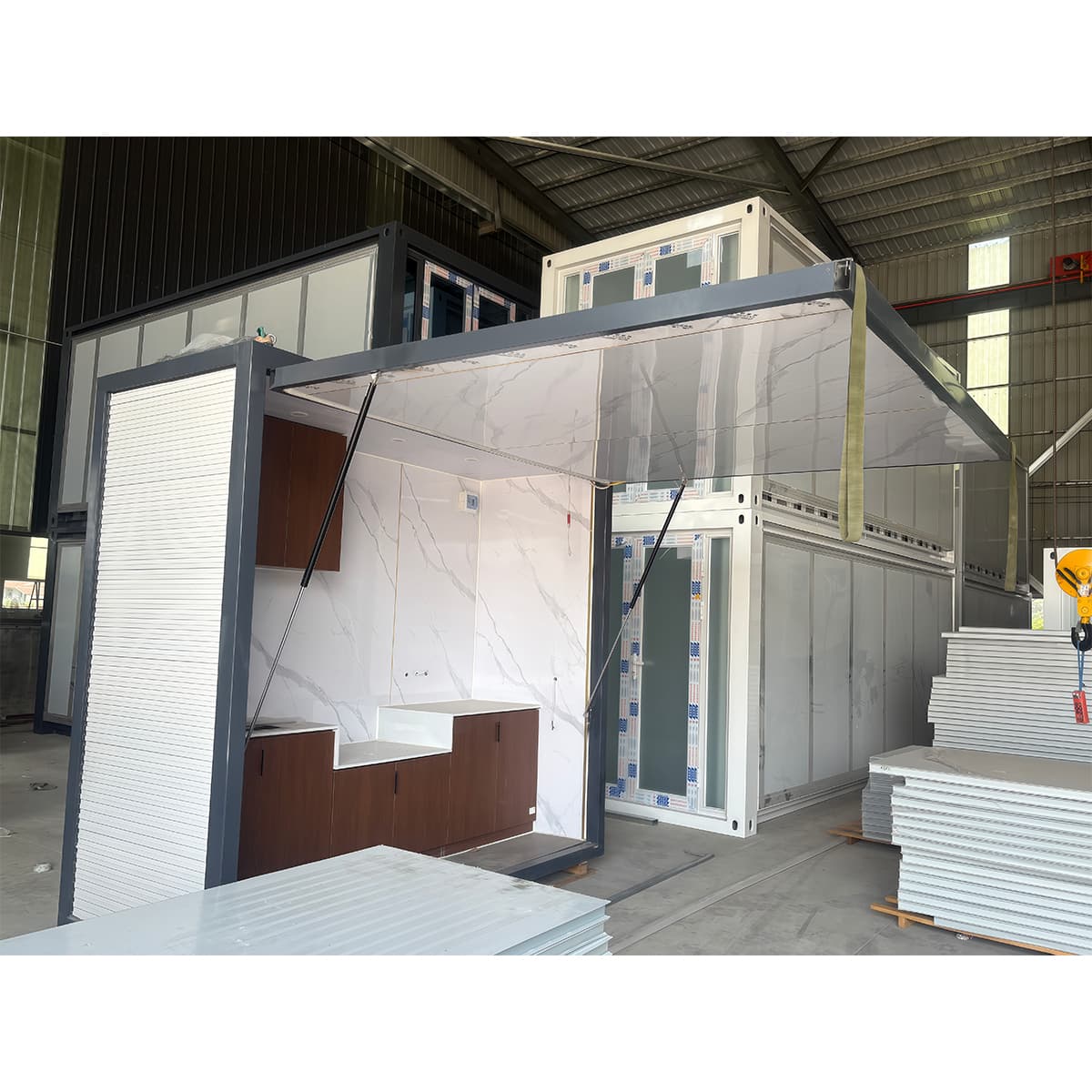 Two complete foldable container kitchen modules with serving panels open and fitted counters visible